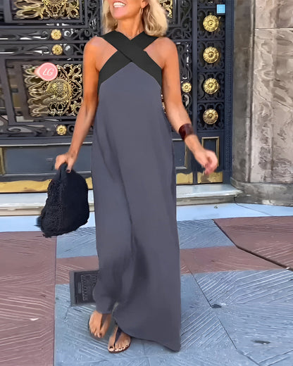 Gray sleeveless maxi dress with cross halter neckline and draped skirt