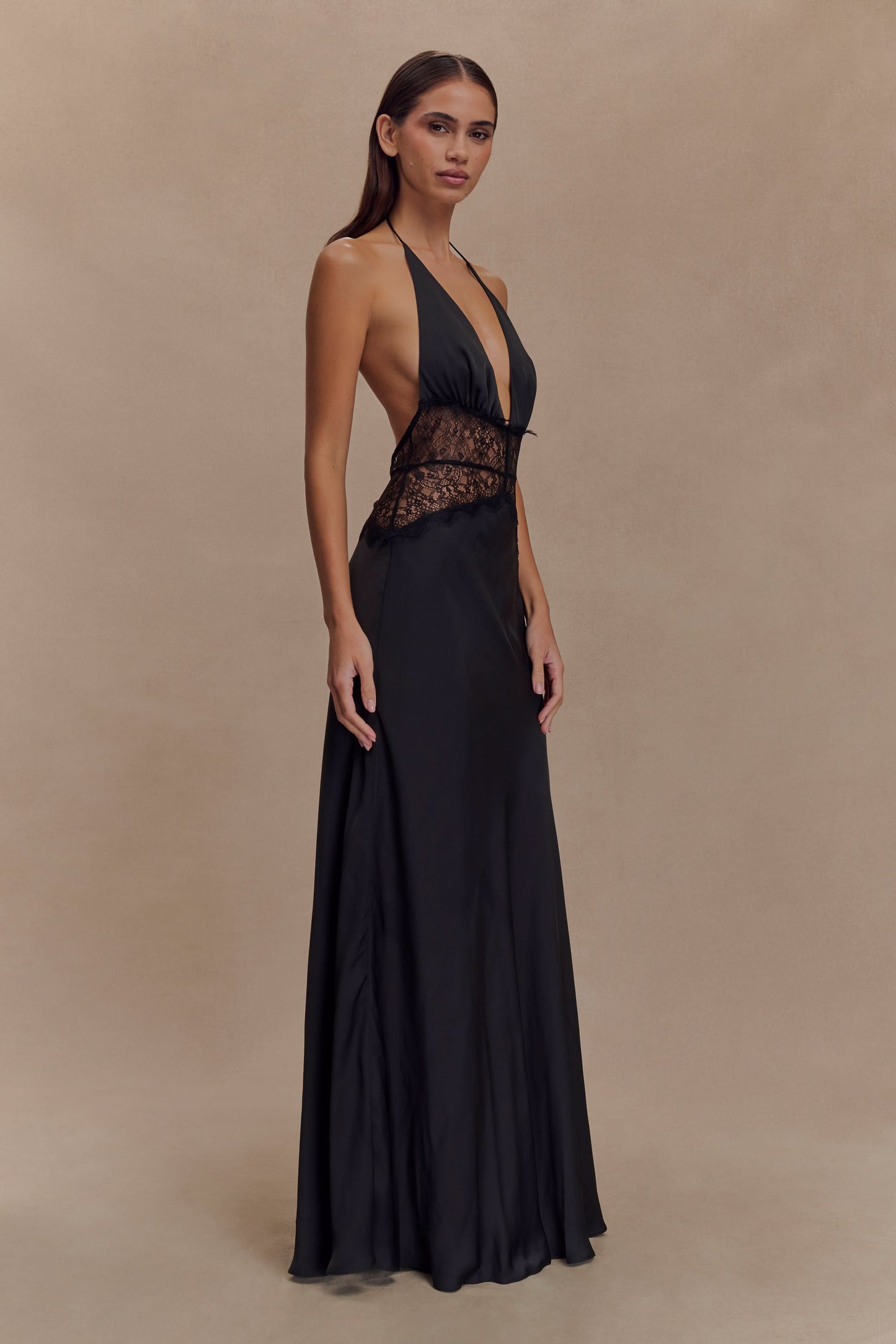 Side view of black lace maxi dress with halter neckline and flowing skirt