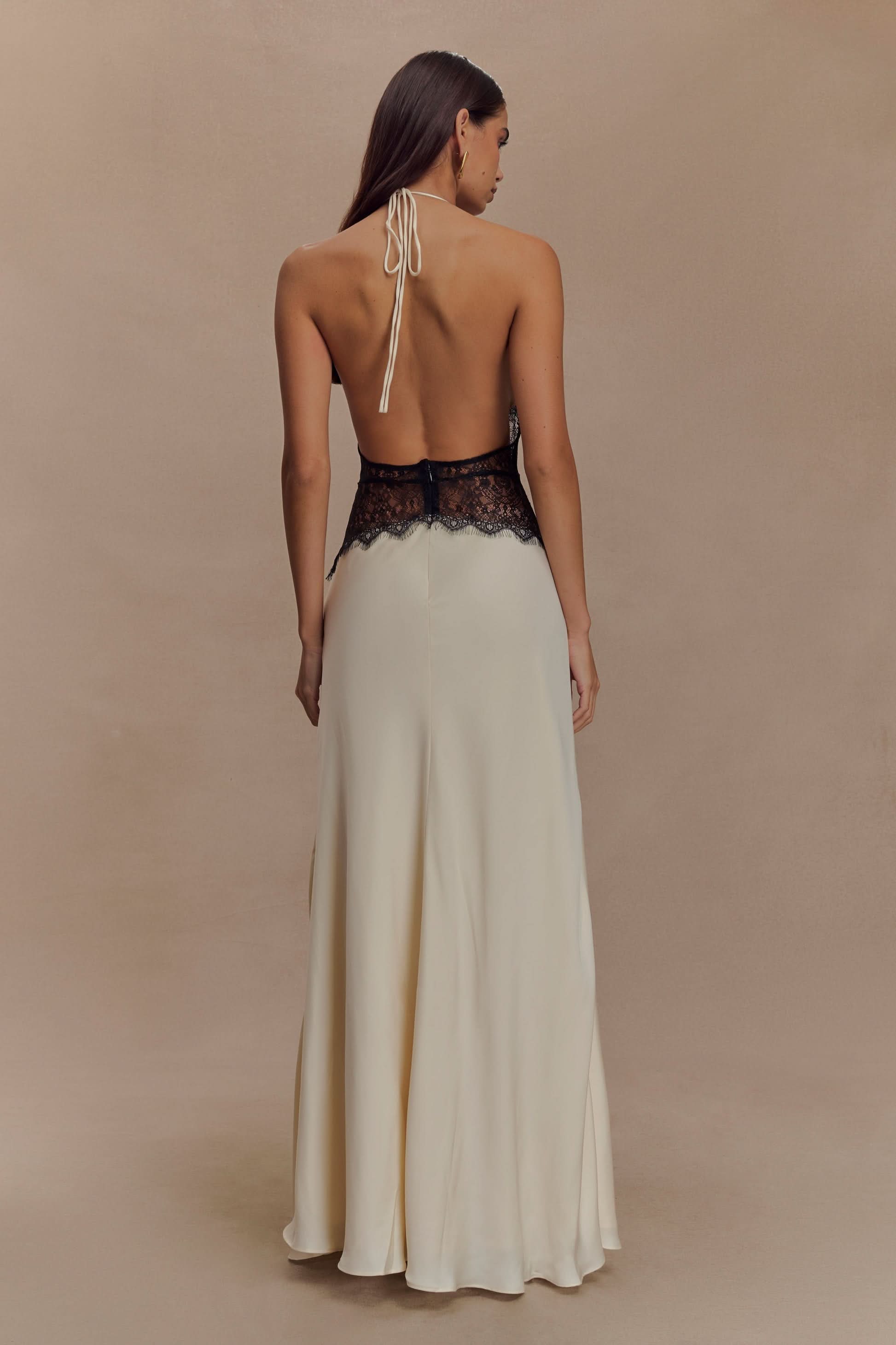 Back view of cream maxi dress with black lace waist and halter tie