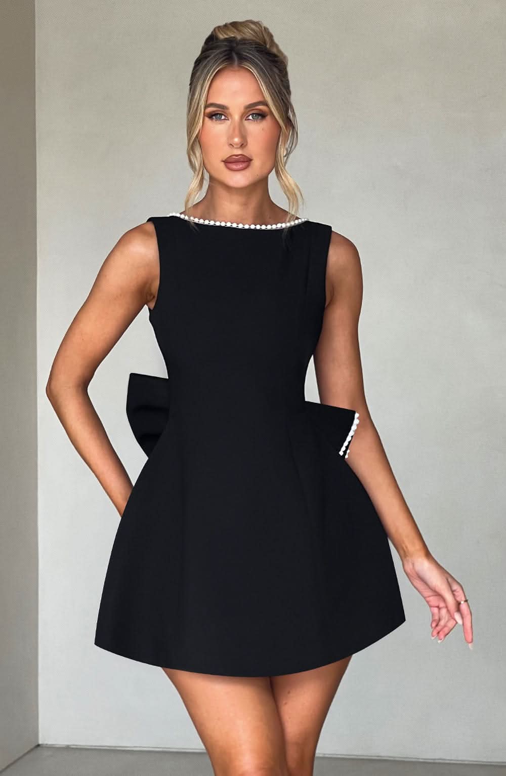 Black mini dress with pearl-trimmed neckline and side pocket details