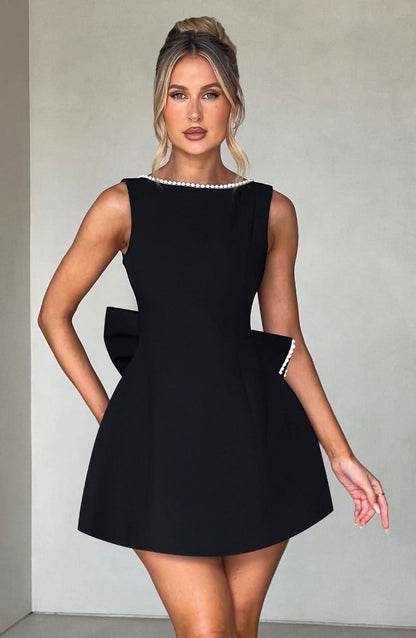 Black mini dress with pearl-trimmed neckline and side pocket details