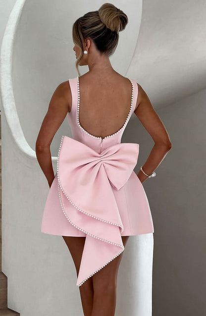 Black mini dress with pearl-beaded back and dramatic bow detail